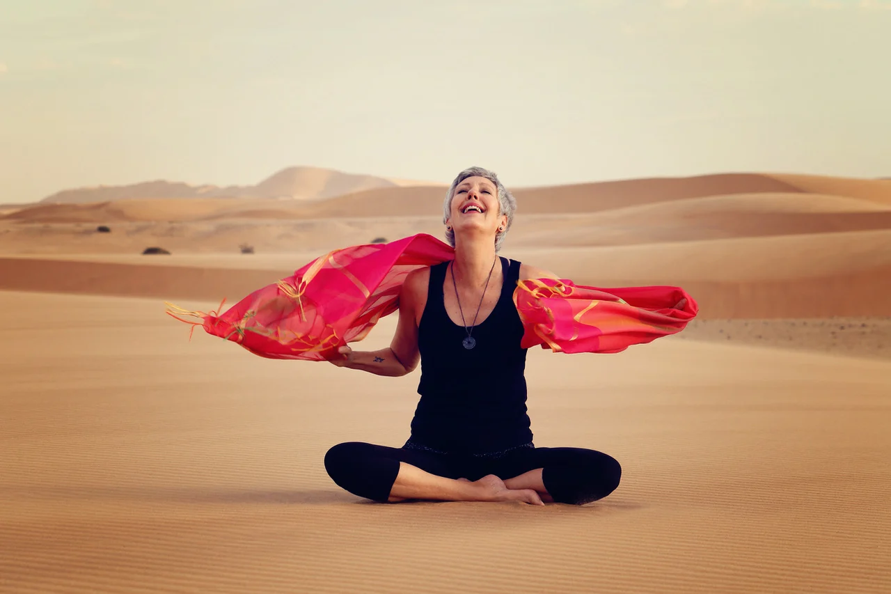 Gabi smiling with an open red wrap in the Namib Desert